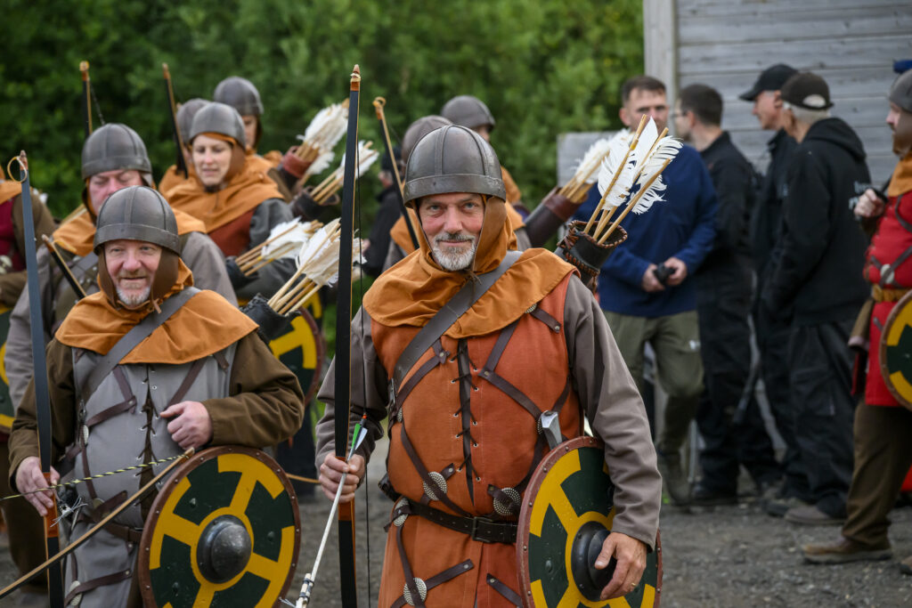 A man dressed as a medieval bowman gets ready to go on stage