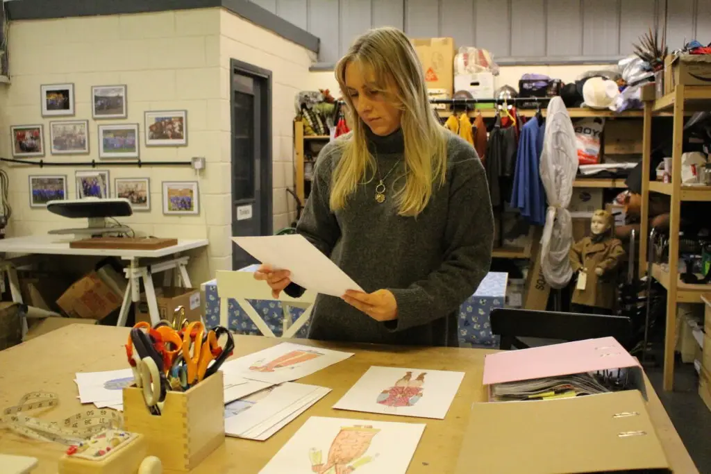 Emily reviews designs in a costume workshop