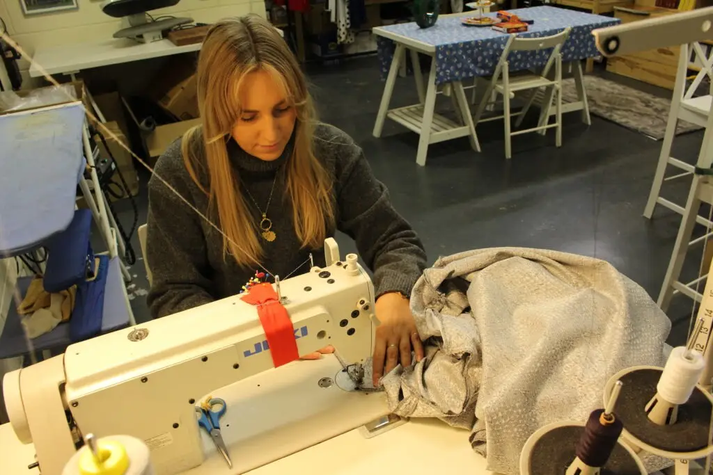 Emily works at a sewing machine