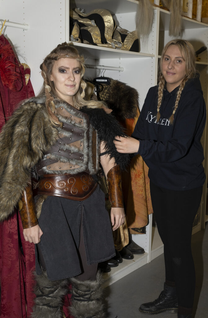 Emily adjusts a costume on a female viking