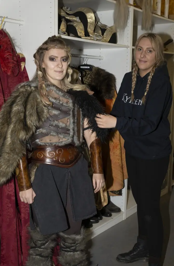 Emily adjusts a costume on a female viking