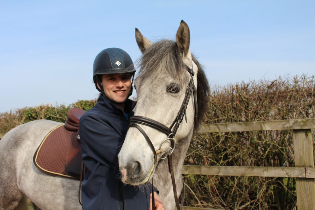 a horse looks at the camera alongside a man from Kynren's cavalry team