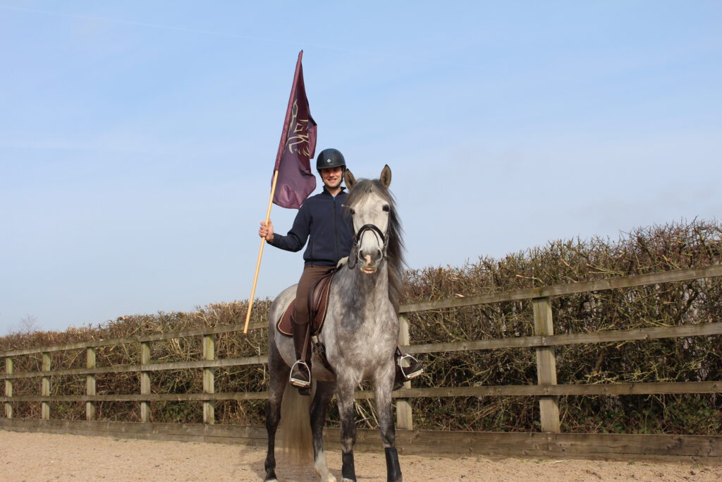 A man from Kynren's cavalry team poses on horseback carrying a flag