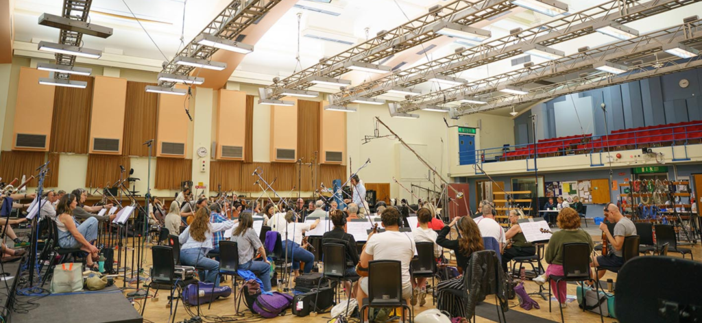 an orchestra plays music in a huge recording studio