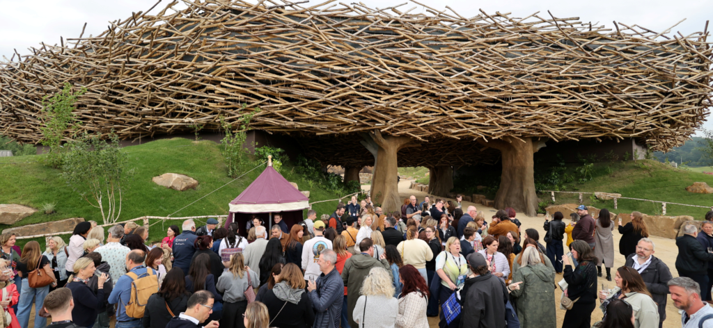 People gather in front of a nest-shaped arena