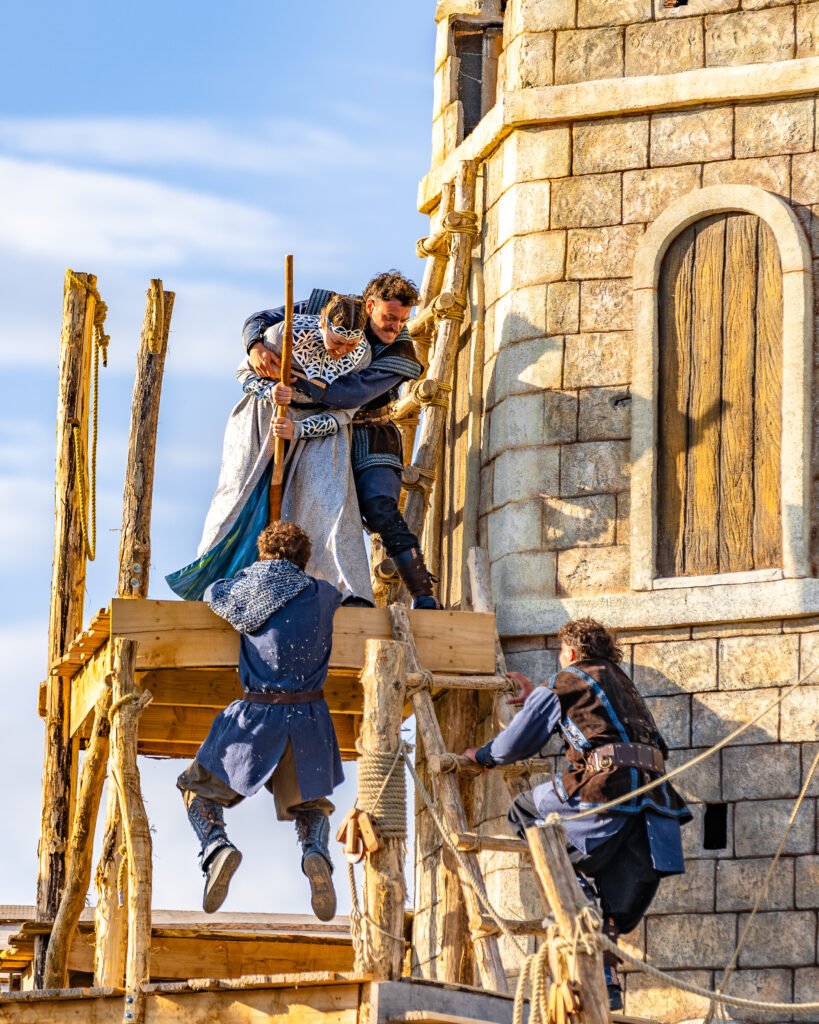 two men hang from parkour platforms while a woman attempts to push them from them in Legend of the Wear