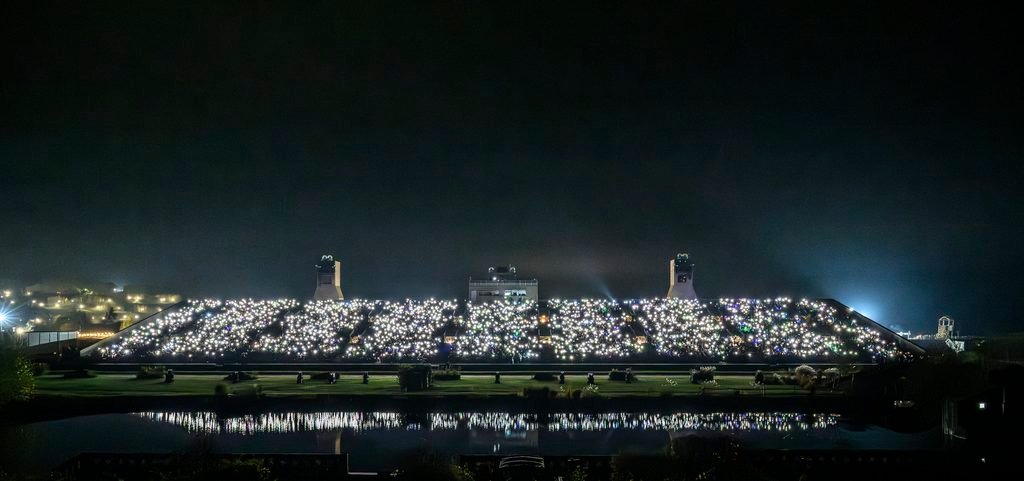 torches glow from each seat of a 8,000 seater tribune
